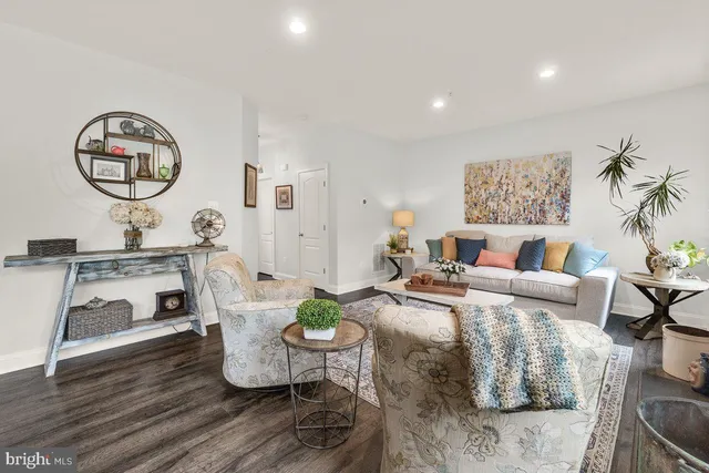 a living room with furniture and a wooden floor