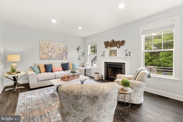a living room with furniture two window and a fireplace
