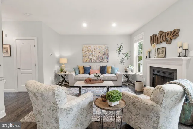 a living room with fireplace furniture and a potted plant