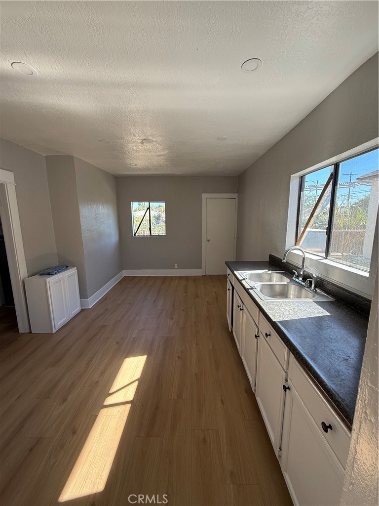 2853 East 6th Street, Unit 2 Los Angeles, CA 90023 - Photo 13 of 14 a open kitchen with kitchen island granite countertop a sink stove and wooden cabinets