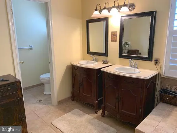 a bathroom with a granite countertop sink and a bathtub