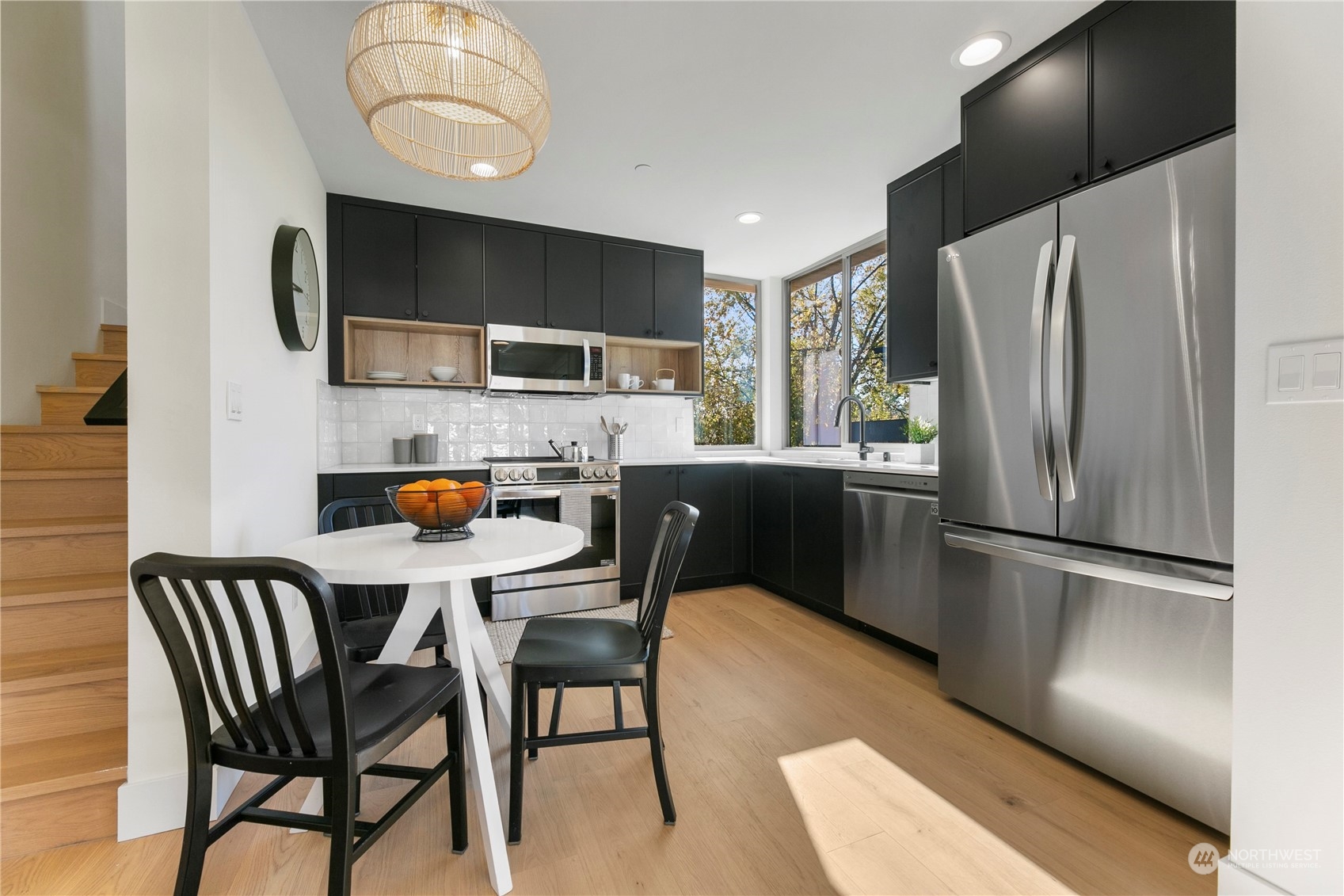 3617 South Hanford Street Seattle, WA 98144 - Photo 8 of 32 a kitchen with stainless steel appliances a refrigerator a stove a microwave oven a sink with island and chairs