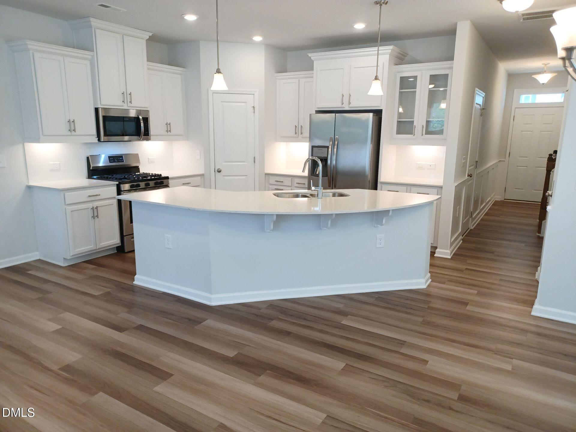 6079 Beale Loop Raleigh, NC 27616 - Photo 1 of 22 a large kitchen with stainless steel appliances kitchen island granite countertop a large counter top and wooden floors