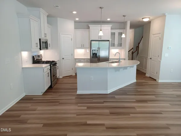 a large kitchen with kitchen island a sink stainless steel appliances and cabinets
