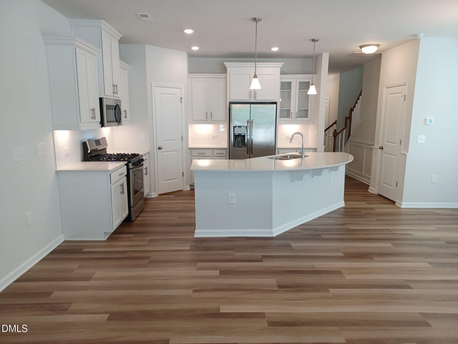 6079 Beale Loop Raleigh, NC 27616 - Photo 3 of 22 a large kitchen with kitchen island a sink stainless steel appliances and cabinets