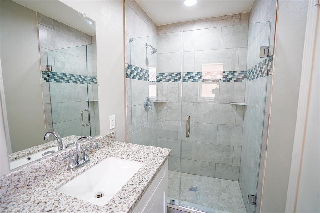 7130 Heath Street Houston, TX 77016 - Photo 11 of 18 a bathroom with a granite countertop sink a mirror and shower
