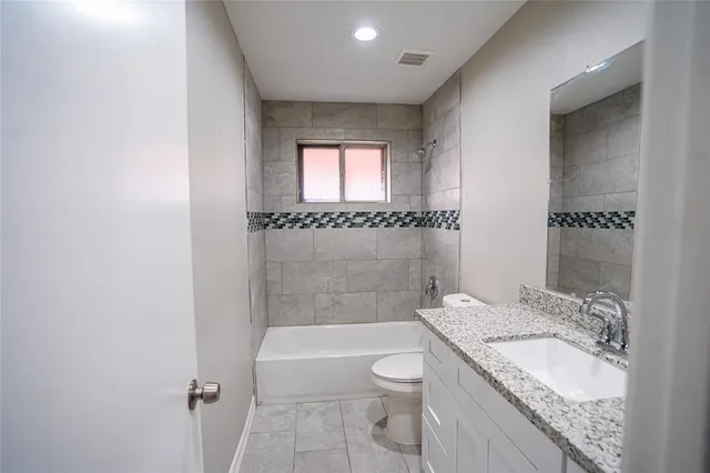 a bathroom with a granite countertop shower and a toilet