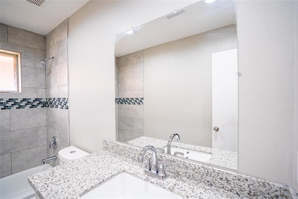7130 Heath Street Houston, TX 77016 - Photo 3 of 18 a bathroom with a granite countertop sink and a mirror