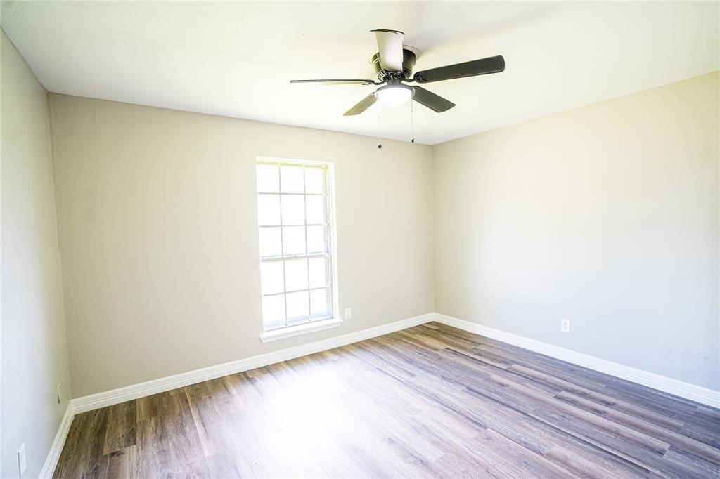 7130 Heath Street Houston, TX 77016 - Photo 9 of 18 an empty room with wooden floor fan and windows
