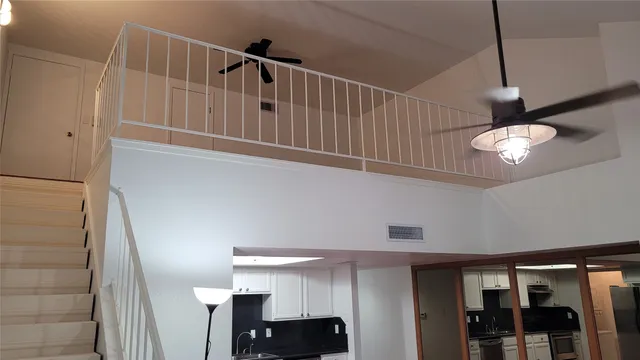 a view of staircase with railing and white walls