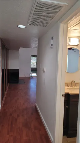 a view of hallway with sink and wooden floor
