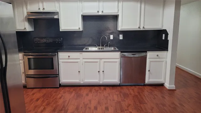 a kitchen with granite countertop white cabinets and black appliances