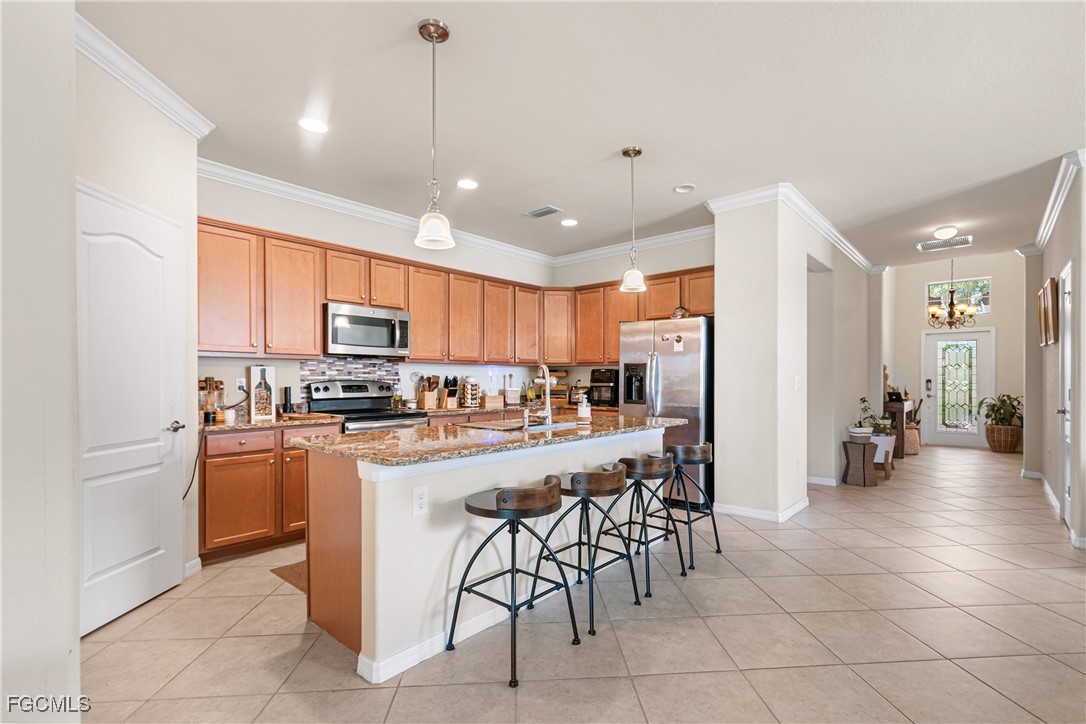 11656 Eros Road Lehigh Acres, FL 33971 - Photo 15 of 49 a kitchen with stainless steel appliances a refrigerator oven a sink a dining table and chairs