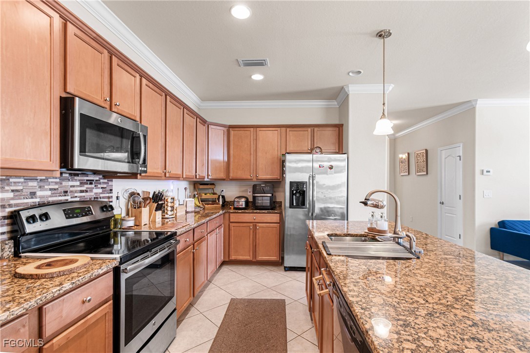 11656 Eros Road Lehigh Acres, FL 33971 - Photo 16 of 49 a kitchen with a sink stove top oven and refrigerator