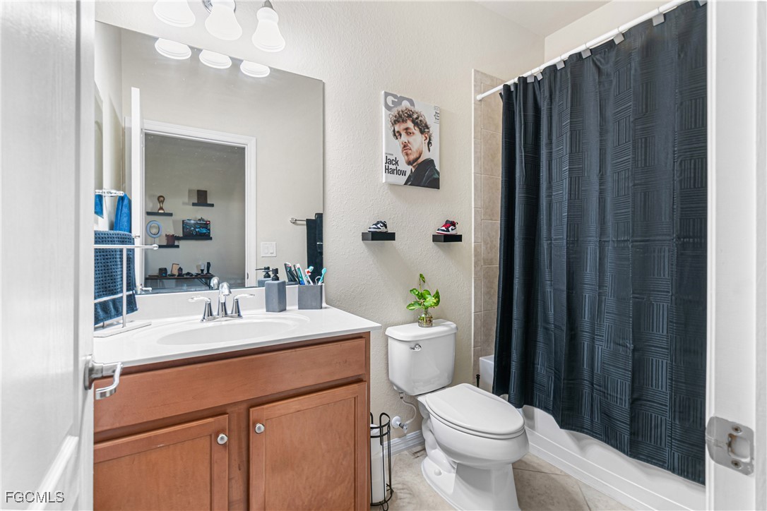 11656 Eros Road Lehigh Acres, FL 33971 - Photo 32 of 49 a bathroom with a sink a toilet a mirror and shower curtain