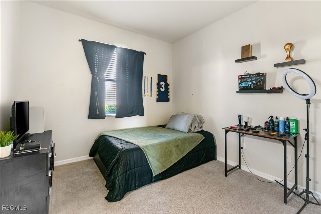 11656 Eros Road Lehigh Acres, FL 33971 - Photo 33 of 49 a bedroom with a bed and a television