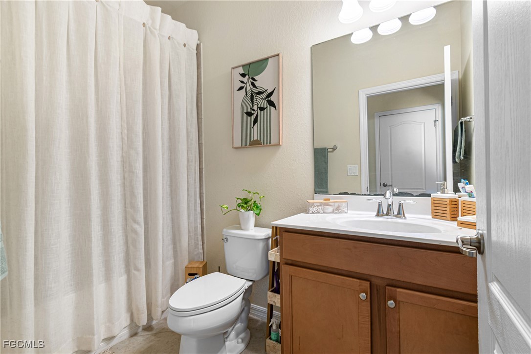 11656 Eros Road Lehigh Acres, FL 33971 - Photo 35 of 49 a bathroom with a sink a toilet and a mirror