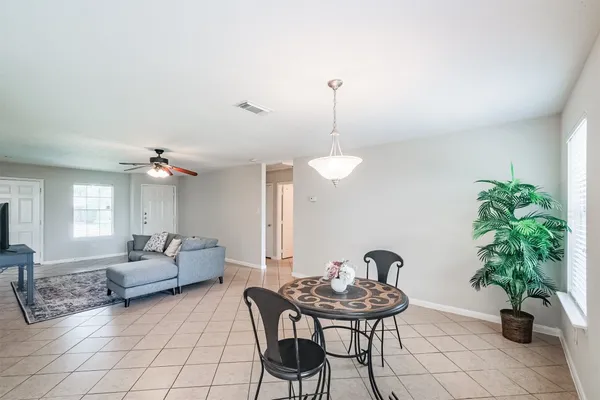 a living room with furniture a potted plant and a chandelier