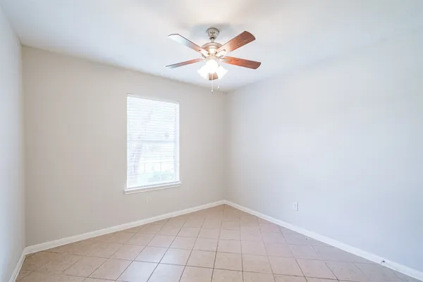 an empty room with chandelier fan