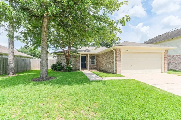 front view of a house with a yard and a garage