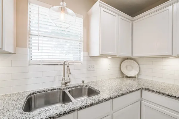 a kitchen with granite countertop a sink and a window