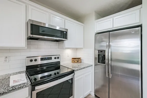 a kitchen with stainless steel appliances and cabinets