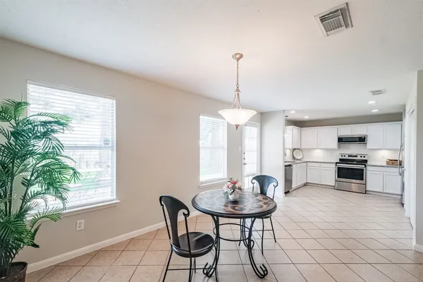a view of a dining room and livingroom furniture wooden floor a chandelier and a mirror