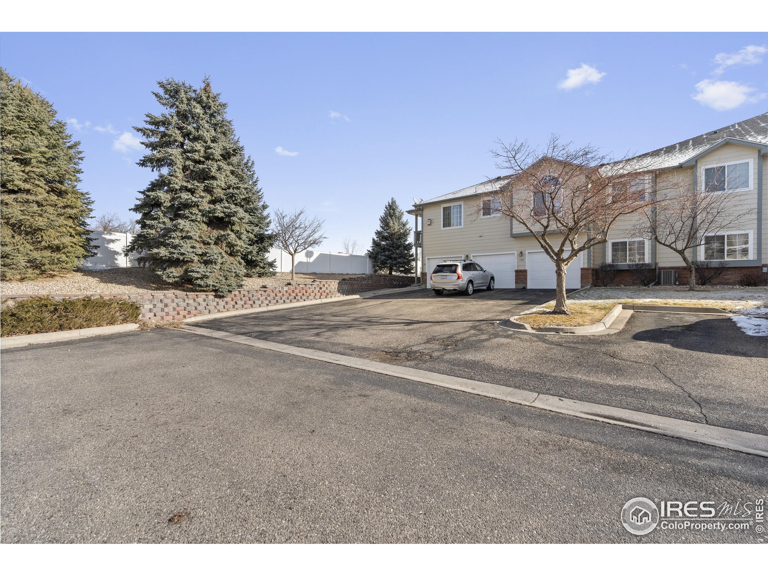 5151 29th Street, Unit 1311 Greeley, CO 80634 - Photo 14 of 16 a view of a house with a yard and garage