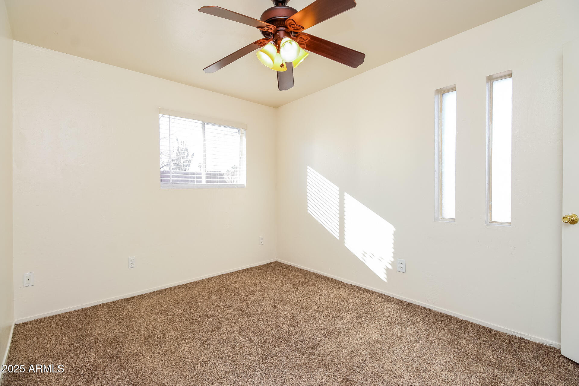 1326 North Miller Road, Unit B Tempe, AZ 85288 - Photo 9 of 11 an empty room with windows and fan