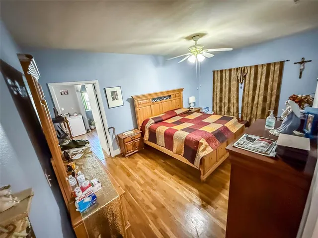 a bedroom with a bed lamps and a large mirror on the dresser