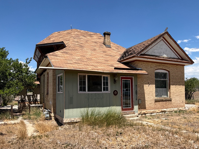 255 E Centre Spring City, UT 84662 - Photo 3 of 34 Brick and siding exterior featuring an arched entrance, multi-pane windows, and a red front door