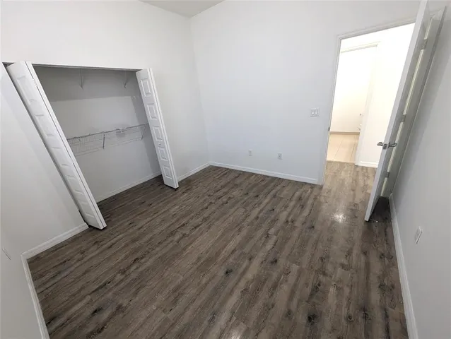 an empty room with wooden floor and entrance