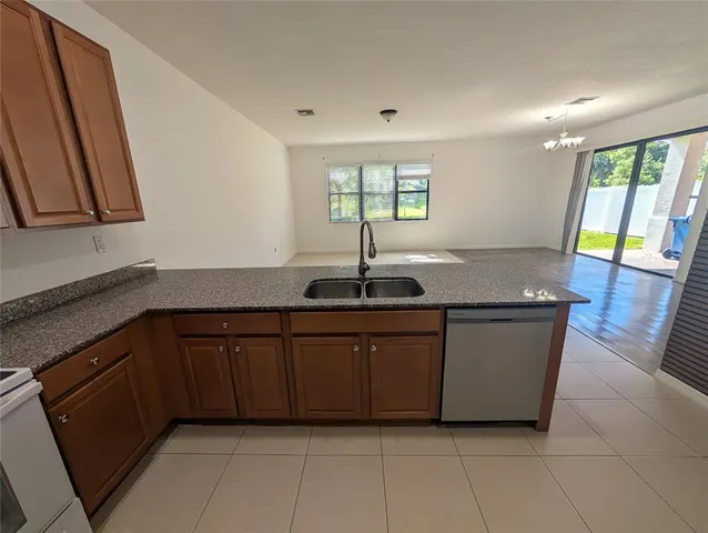a kitchen with granite countertop a sink and a stove