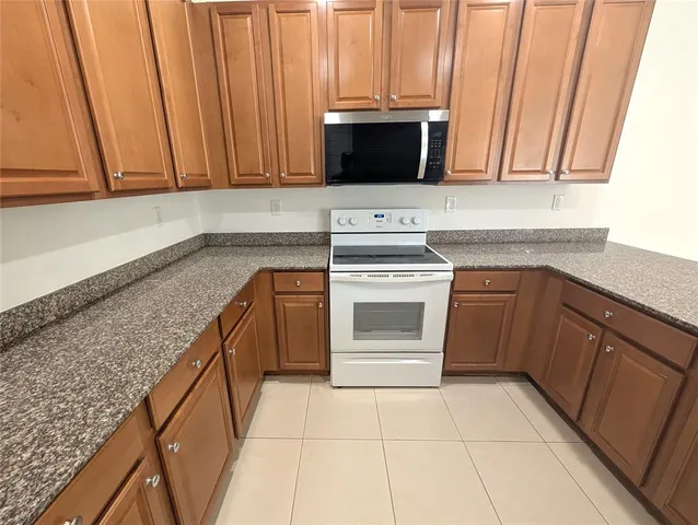 a kitchen with stainless steel appliances granite countertop a sink and a microwave