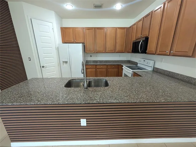 a kitchen with stainless steel appliances granite countertop a sink and a granite counter top