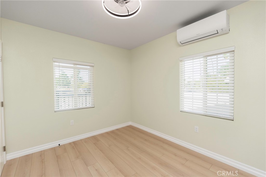 3895 Castleman Street Riverside, CA 92503 - Photo 12 of 22 a view of an empty room with wooden floor and a window