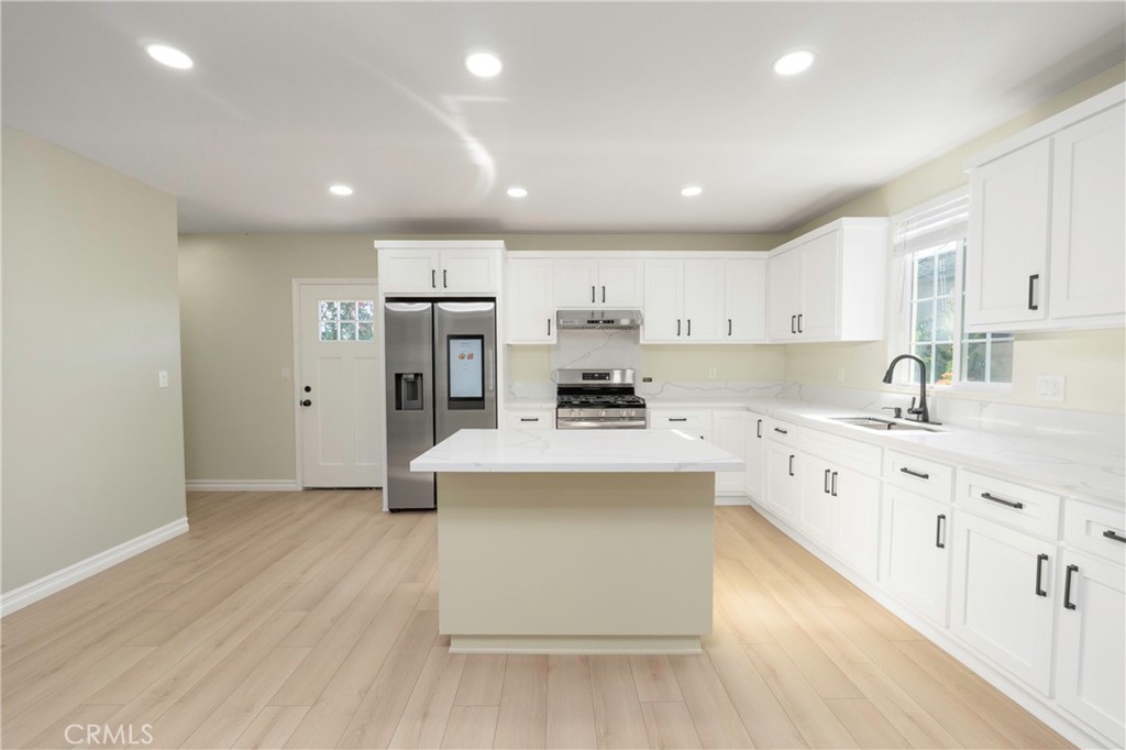 3895 Castleman Street Riverside, CA 92503 - Photo 16 of 22 a large kitchen with kitchen island a sink a center island stainless steel appliances and a counter space