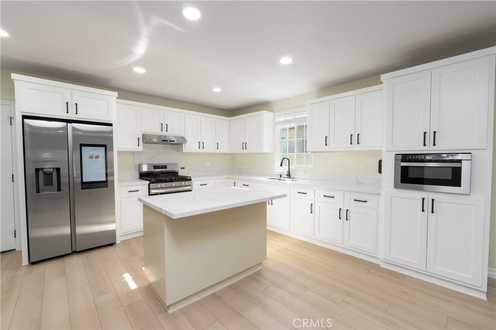 3895 Castleman Street Riverside, CA 92503 - Photo 4 of 22 a kitchen with stainless steel appliances a stove a sink a refrigerator a window