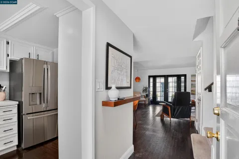 a kitchen with stainless steel appliances granite countertop a refrigerator a stove and a dining table with wooden floor