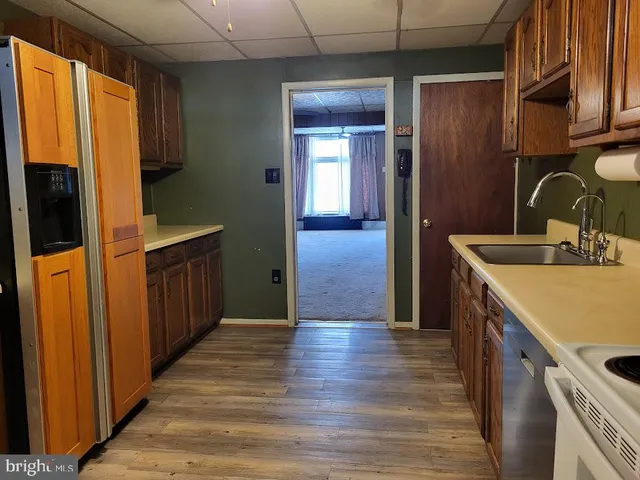 a kitchen with stainless steel appliances granite countertop a sink dishwasher stove and cabinets with wooden floor