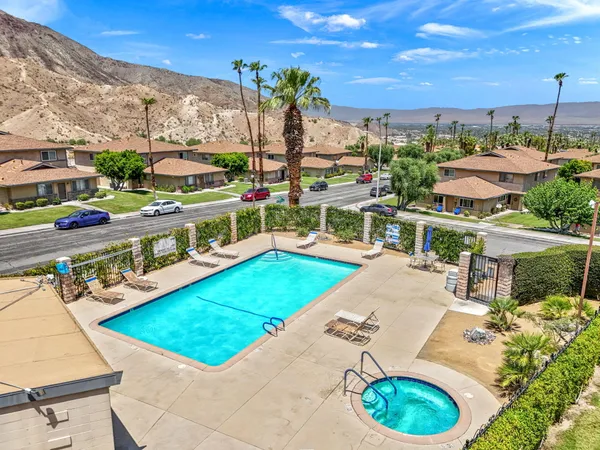 a view of a swimming pool with a chairs and tables in the patio