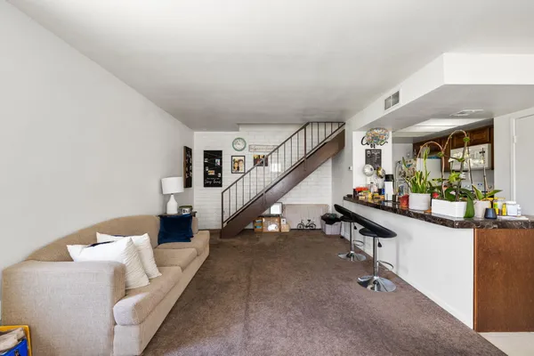 a living room with furniture and stairs