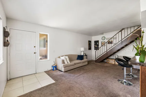 a living room with furniture and stairs
