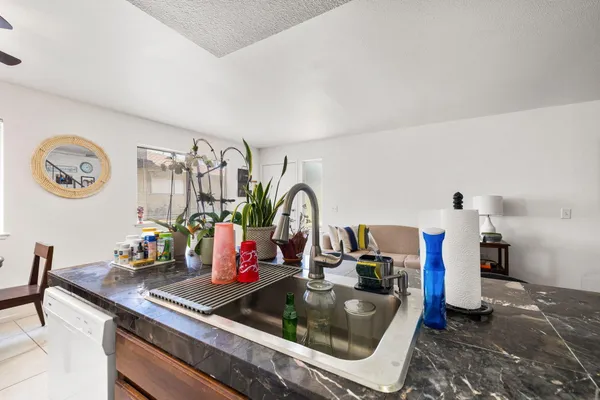 a kitchen with a sink and a stove with white countertops