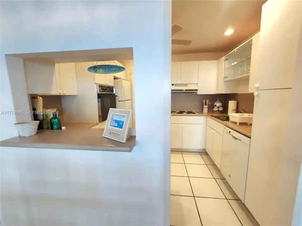 a kitchen with granite countertop a refrigerator a sink a stove a microwave a counter top and oven
