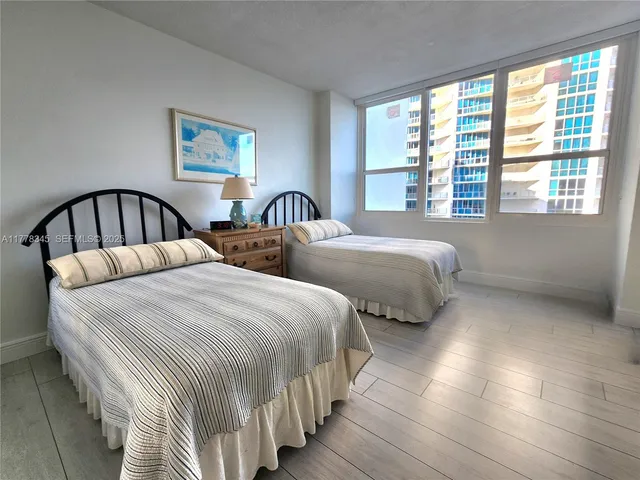 a bedroom with two beds and a large window