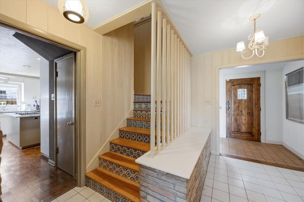 6321 Greenway Road Fort Worth, TX 76116 - Photo 26 of 40 Entryway with light tile patterned flooring, hanging lights, and wooden walls