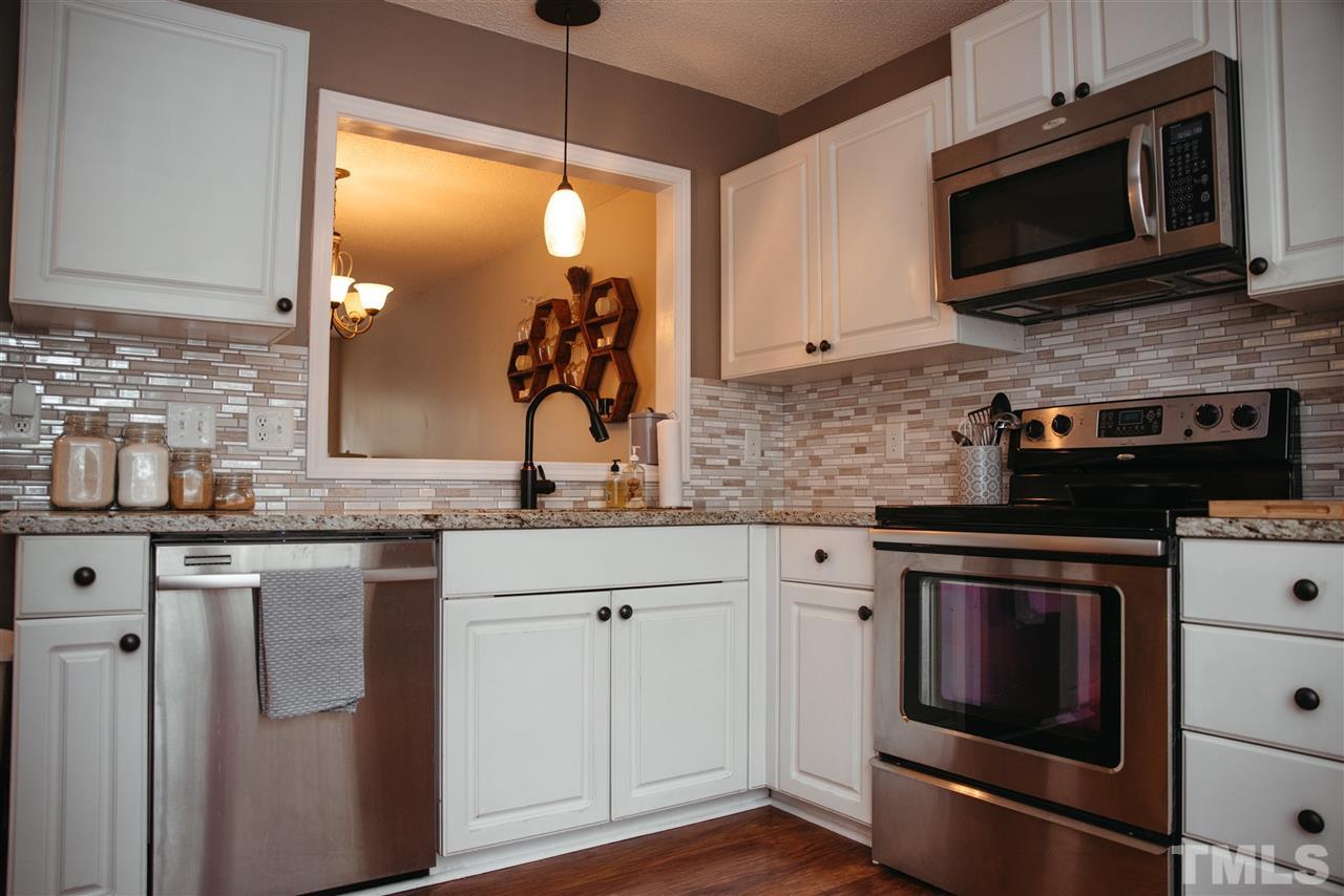 7020 Epping Forest Drive Raleigh, NC 27613 - Photo 2 of 29 a kitchen with stainless steel appliances granite countertop a stove microwave and sink