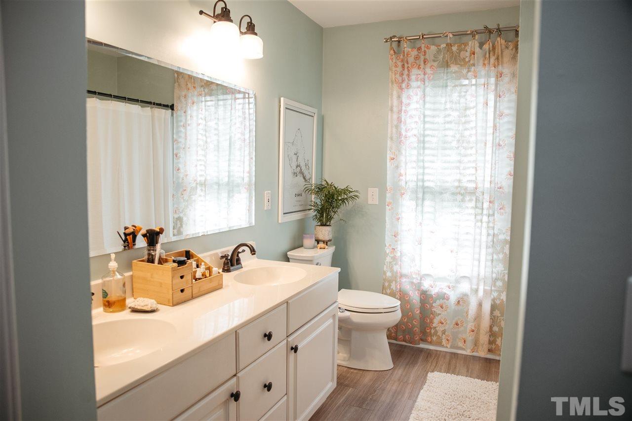 7020 Epping Forest Drive Raleigh, NC 27613 - Photo 17 of 29 a bathroom with a sink toilet and window