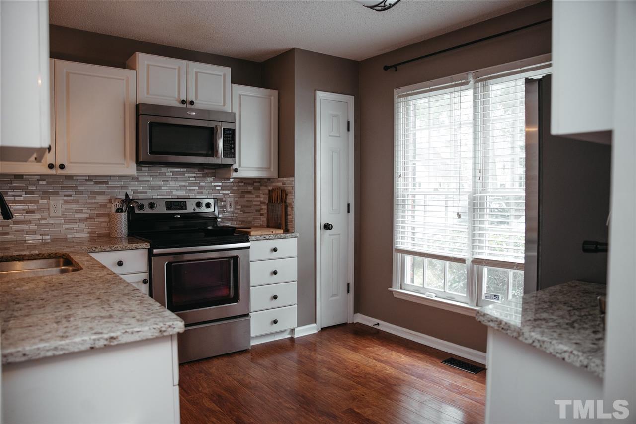 7020 Epping Forest Drive Raleigh, NC 27613 - Photo 3 of 29 a kitchen with stainless steel appliances granite countertop a stove a sink and a microwave